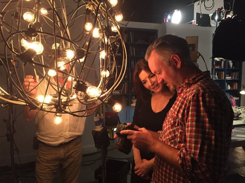 Robin Fox and Nigella Lawson look at the viewscreen of a Canon EOS 5D Mark II on set, next to a large low light fitting.