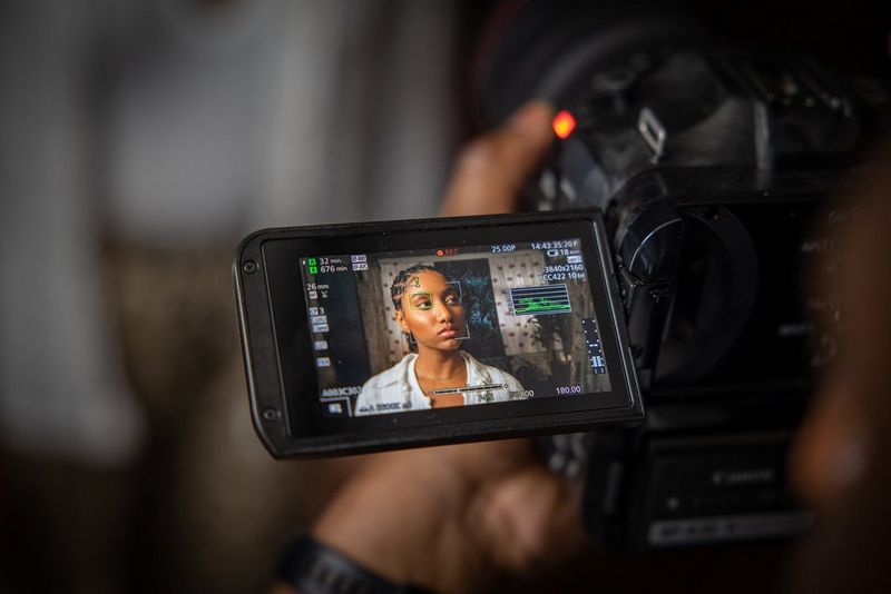 The touchscreen on a Canon EOS C70 showing a woman's face with focus guide indicators.