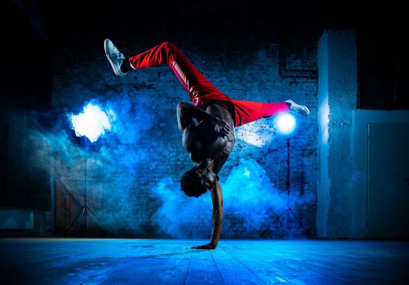 Danseuse de ballet en body noir saute haut et danse avec de la farine sur la