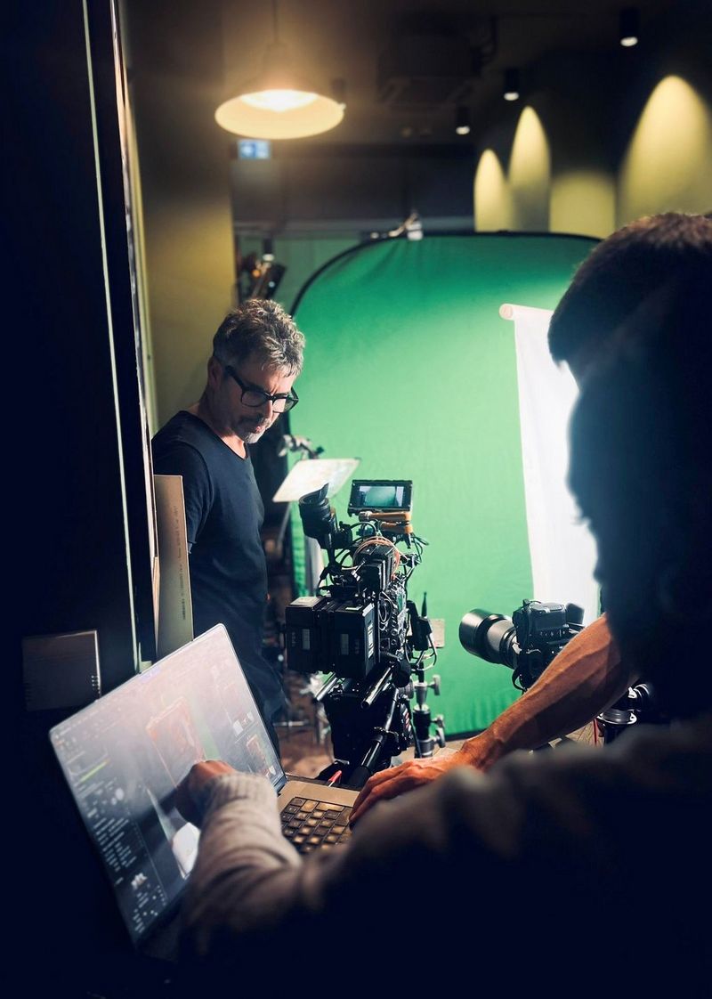 DoP Ian Murray pictured on a shoot in a studio with a green screen in the background. 