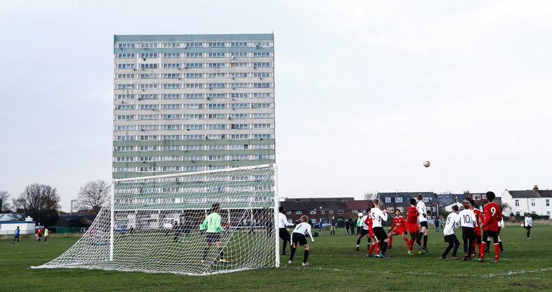 Молодые футболисты играют перед жилым домом в Лондоне.