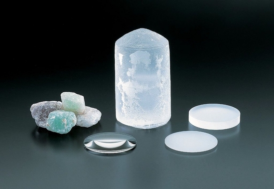 Natural and synthetic fluorite crystals pictured with fluorite lenses.