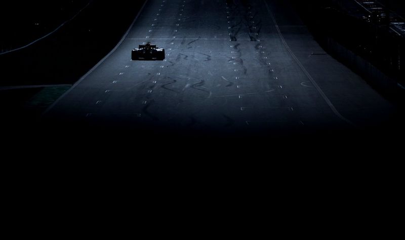 A distant Formula 1 car travels on the left side of a race track, captured on a Canon EOS-1D X Mark II by Vladimir Rys.