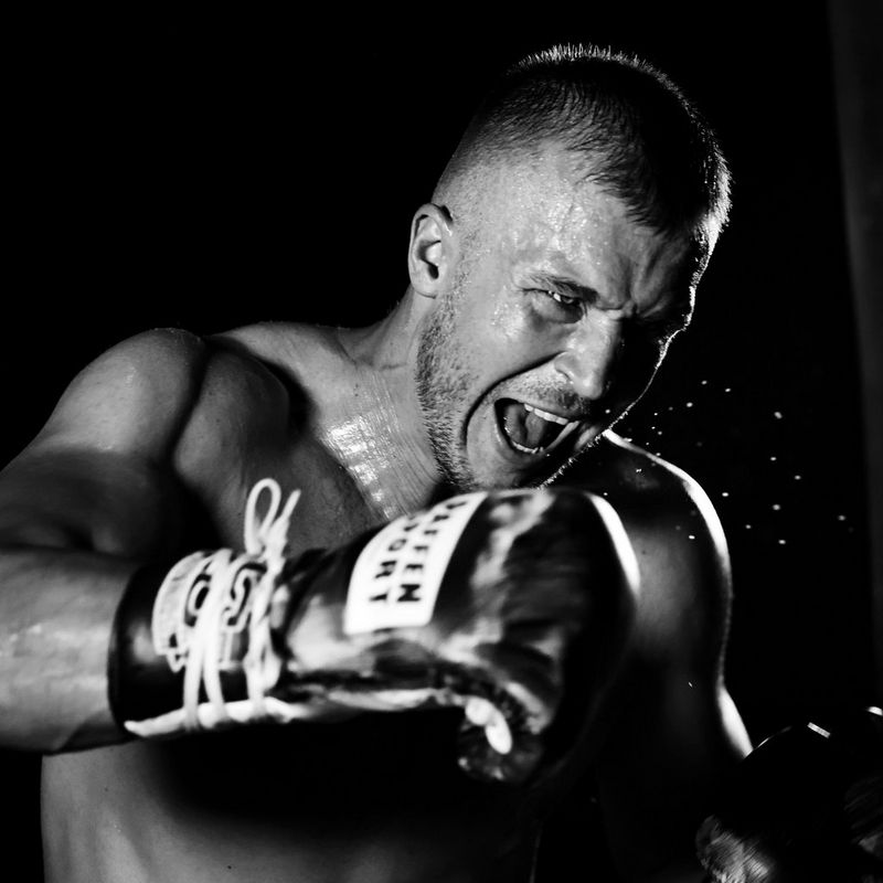A black and white shot of a boxer throwing a punch.