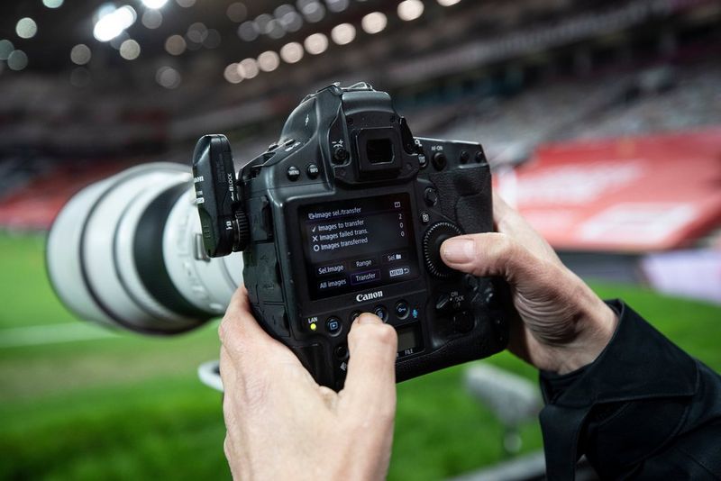 Gros-plan des mains d'Eddie Keogh en train de choisir des images à transférer vers un Canon EOS-1D X Mark III.