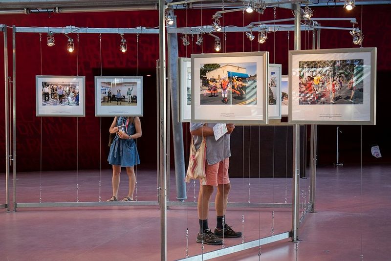 Two people look at framed photographs displayed at the Visa pour l'Image international festival of photojournalism in France. 