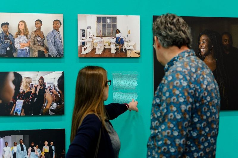 A man and woman look at exhibition prints and text at Ilvy Njiokiktjien’s Born Free exhibition.