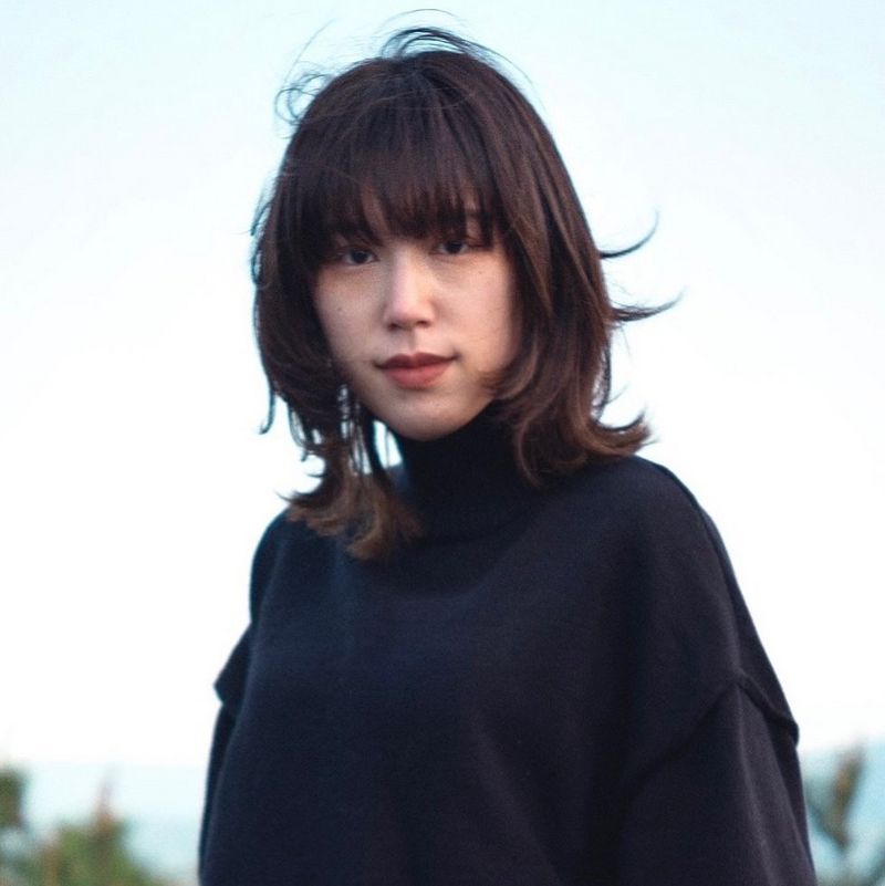 A headshot of Karen Haibara against a blue sky.