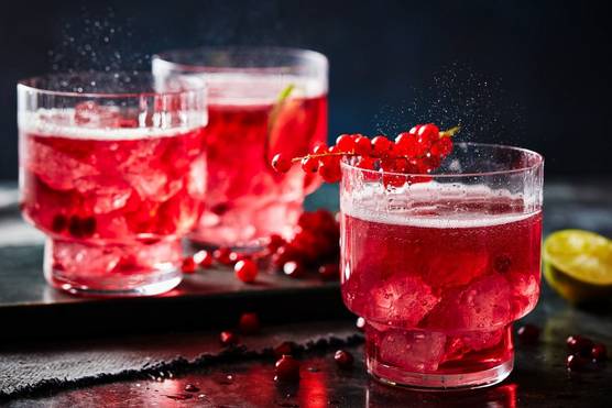 Three glasses of a cranberry drink, filled with ice, fizz temptingly.
