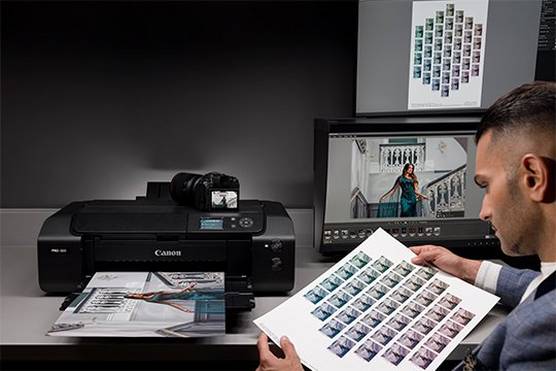 Photographer Sanjay Jogia studies a sheet of image thumbnails printed by a Canon imagePROGRAF PRO-300.