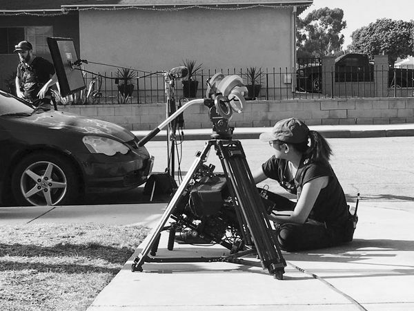 Director Patricia Vidal Delgado sits beside a road with a Canon EOS C500 on a tripod.