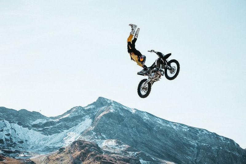 Motocross rider Tom Pagès performs a stunt mid-air with mountains in the background. Taken on a Canon EOS R5 with a Canon RF 100-500mm F4.5-7.1L IS USM lens by Teddy Morellec.