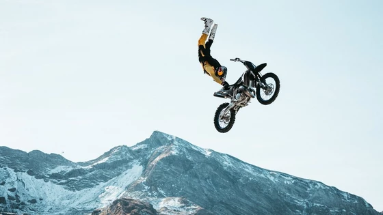 Motocross rider Tom Pagès performs a stunt mid-air with mountains in the background. Taken on a Canon EOS R5 with a Canon RF 100-500mm F4.5-7.1L IS USM lens by Teddy Morellec.