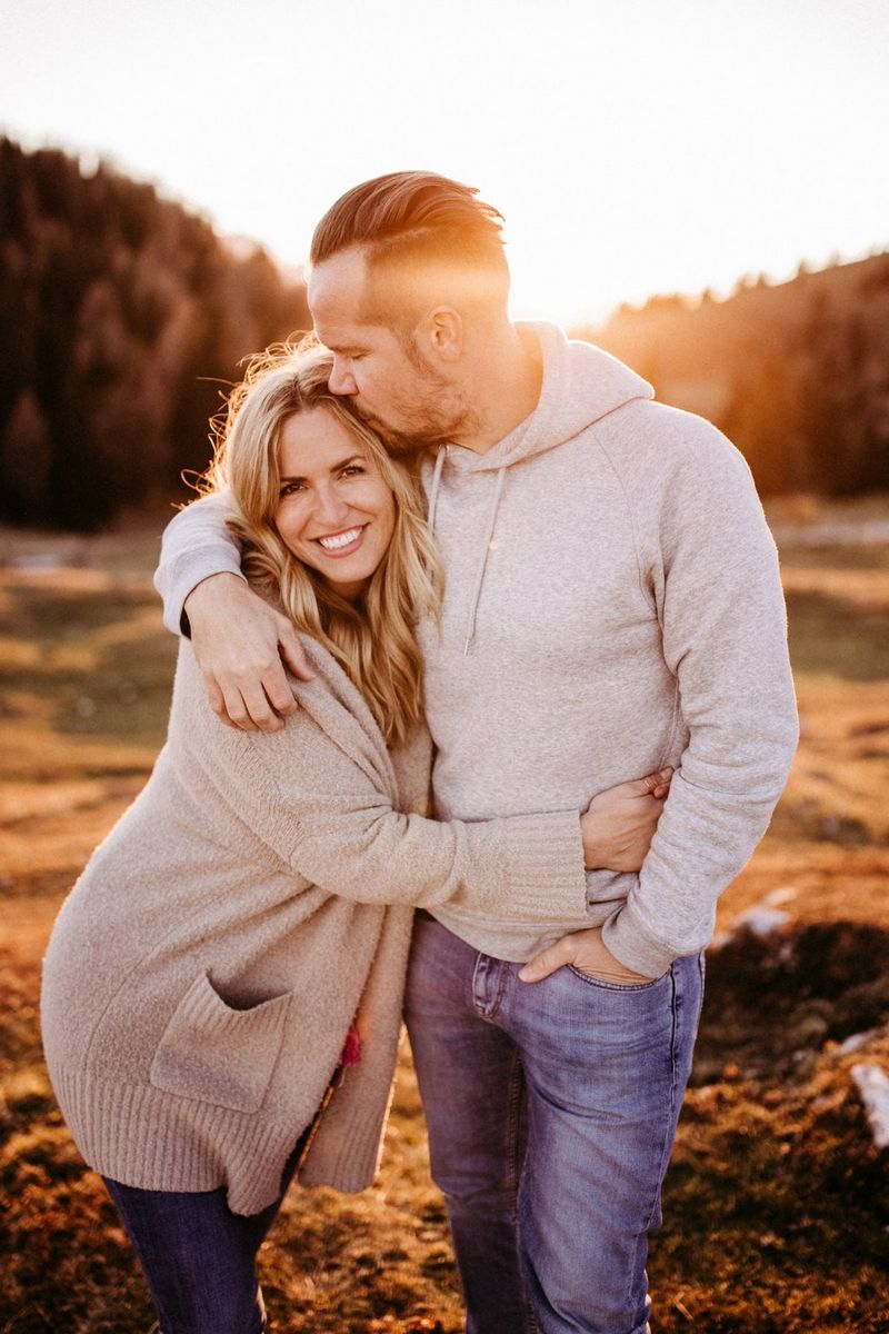 A self-portrait of wedding photography duo Carmen and Ingo embracing as the sun sets behind them. 