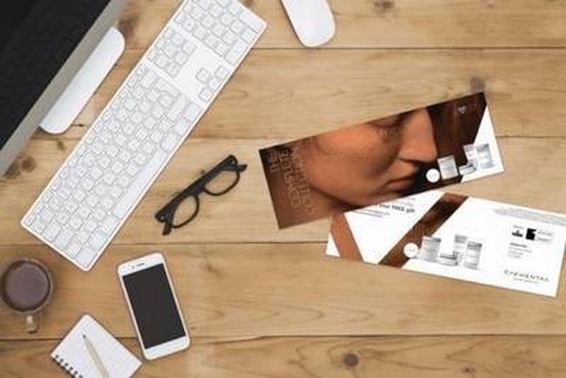 Campaign direct mail on table with computer, glasses and phone
