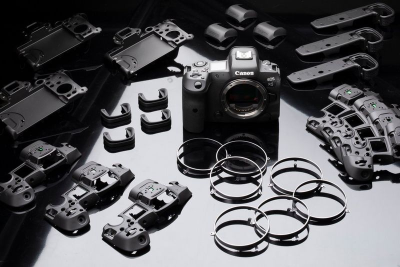 Un Canon EOS R5 entouré de nombreux composants utilisés pour sa création.