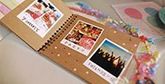 A scrapbook on a table filled with instant camera prints.