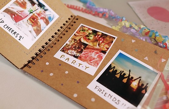 A scrapbook on a table filled with instant camera prints.