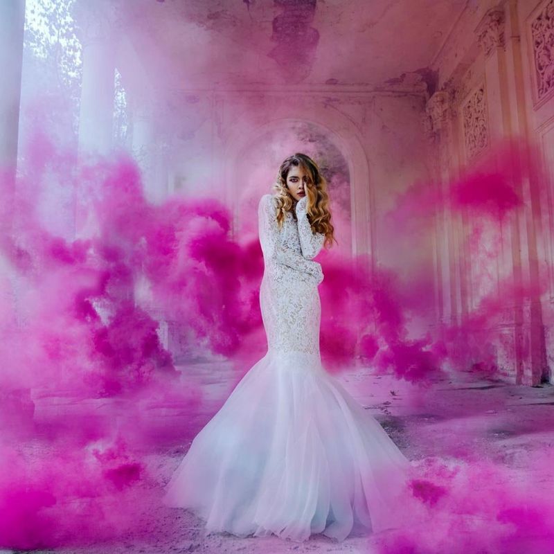 woman in white dress surrounded with pink smoke