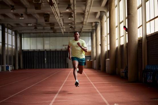 An athlete runs towards the camera as they train indoors in a sports hall, in a photo by Julian Finney captured using a Canon RF 100-300mm F2.8L IS USM lens.