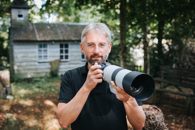 Fotograful Guy Edwardes ţine la ochi un aparat foto Canon cu un obiectiv Canon RF 200-800mm F6.3-9 IS USM ataşat.