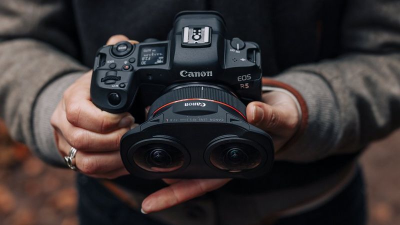 Person holding a Canon camera with a fisheye lens.