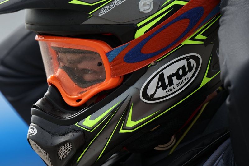 A close-up of a jet skier wearing a helmet and goggles.