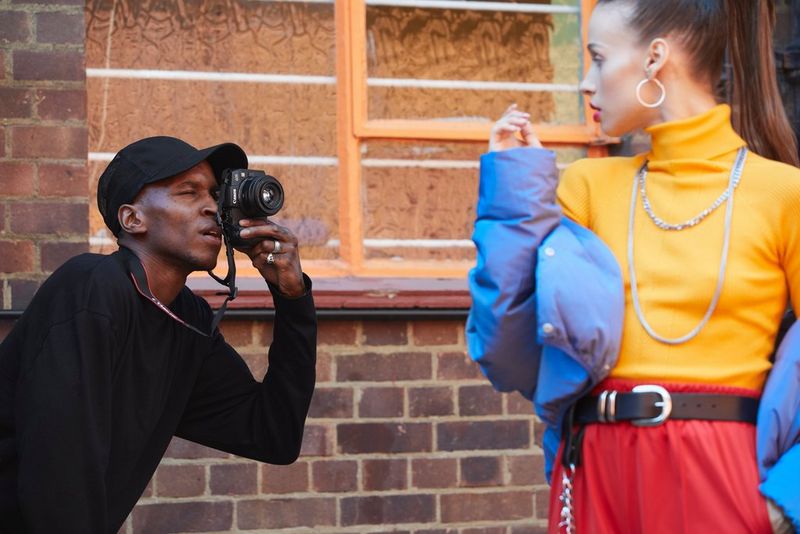Photographer Ejiro Dafé photographs a woman in bright clothing with a Canon EOS R6 and a Canon RF 50mm F1.8 STM lens.