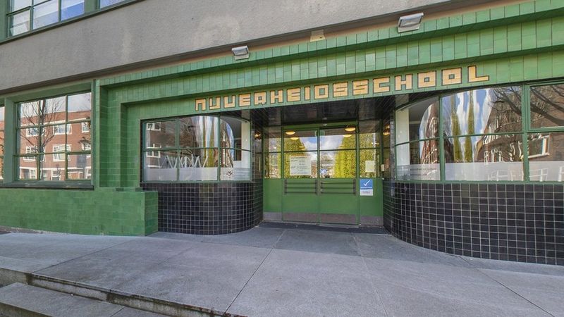 Voorzijde van de oude gevel van de Hanzehogeschool in artdeco stijl met de letters nijverheidsschool hierop.