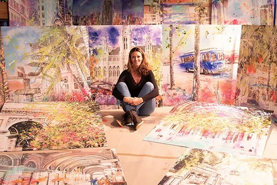 Sophia Rein assise devant ses œuvres d'art