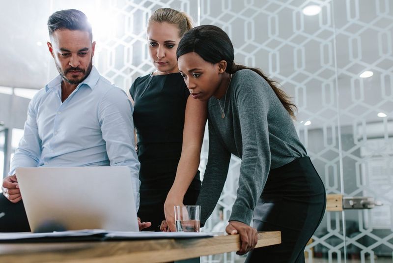 3 personen samen kijken naar een PC