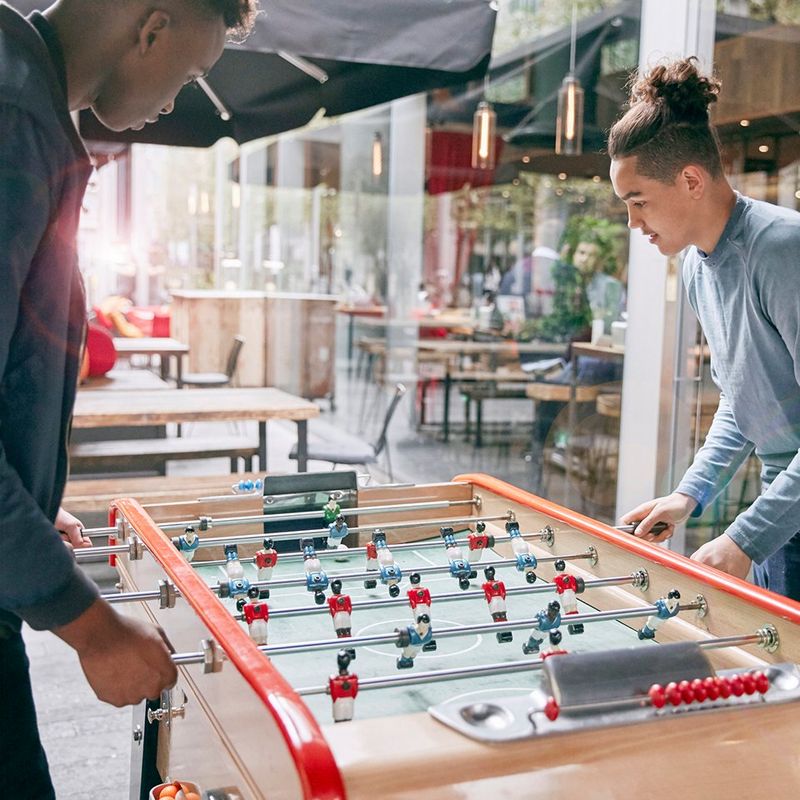 Two men play table football