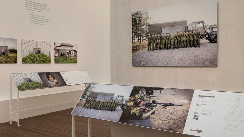 Two perpendicular gallery walls, displaying four hanging photographs. In front of the walls are tactile, elevated print versions of the image, displayed on a sloping stand.