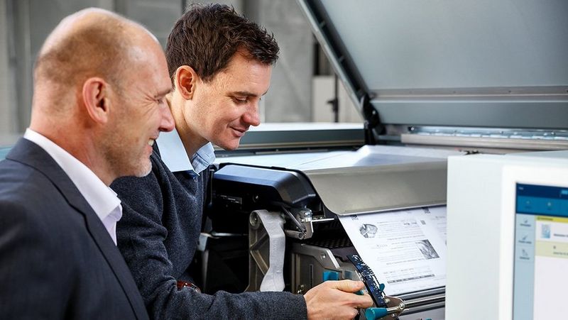 Wrok professional operating Canon printer while the other watches 