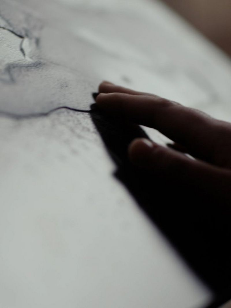 Close up of hands feeling the relief print
