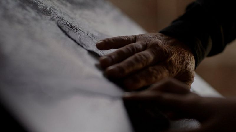 Close up of a hand feeling the relief print 