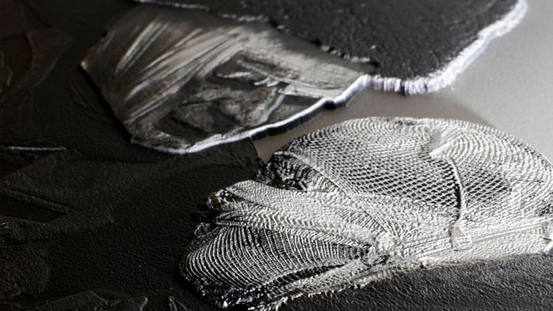 In diesem Schwarz-Weiß-Foto lehnen sich zwei bandagierte Köpfe aneinander. Die Ränder der Köpfe sind jedoch scharf und als Relief auf einem flachen Hintergrund gedruckt.