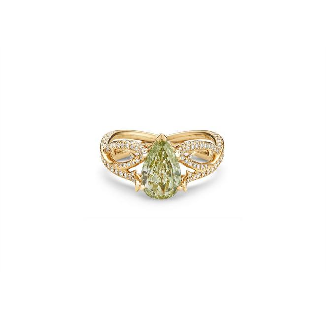 Volute solitaire ring with a fancy yellowish green pear-shaped diamond in yellow gold