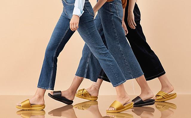 Three pairs of Loosh Lux Sandals shown in Gold and Black and classic and cross-over slides options. 