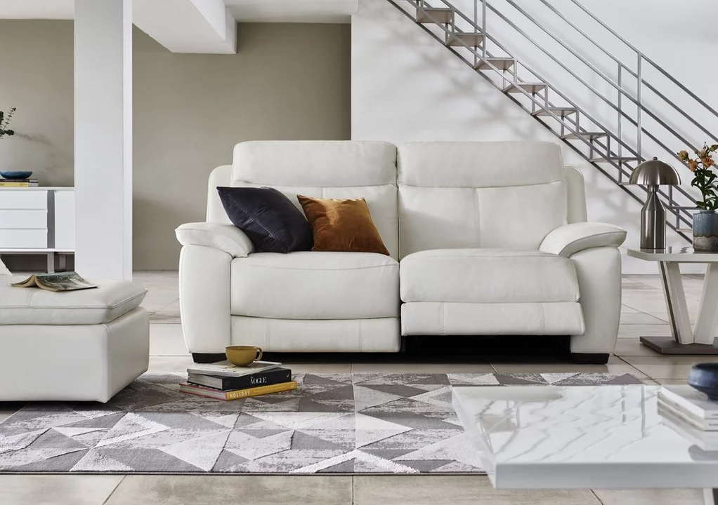 a white sofa colour in a neutral living room with bold cusshion and open metal staircase