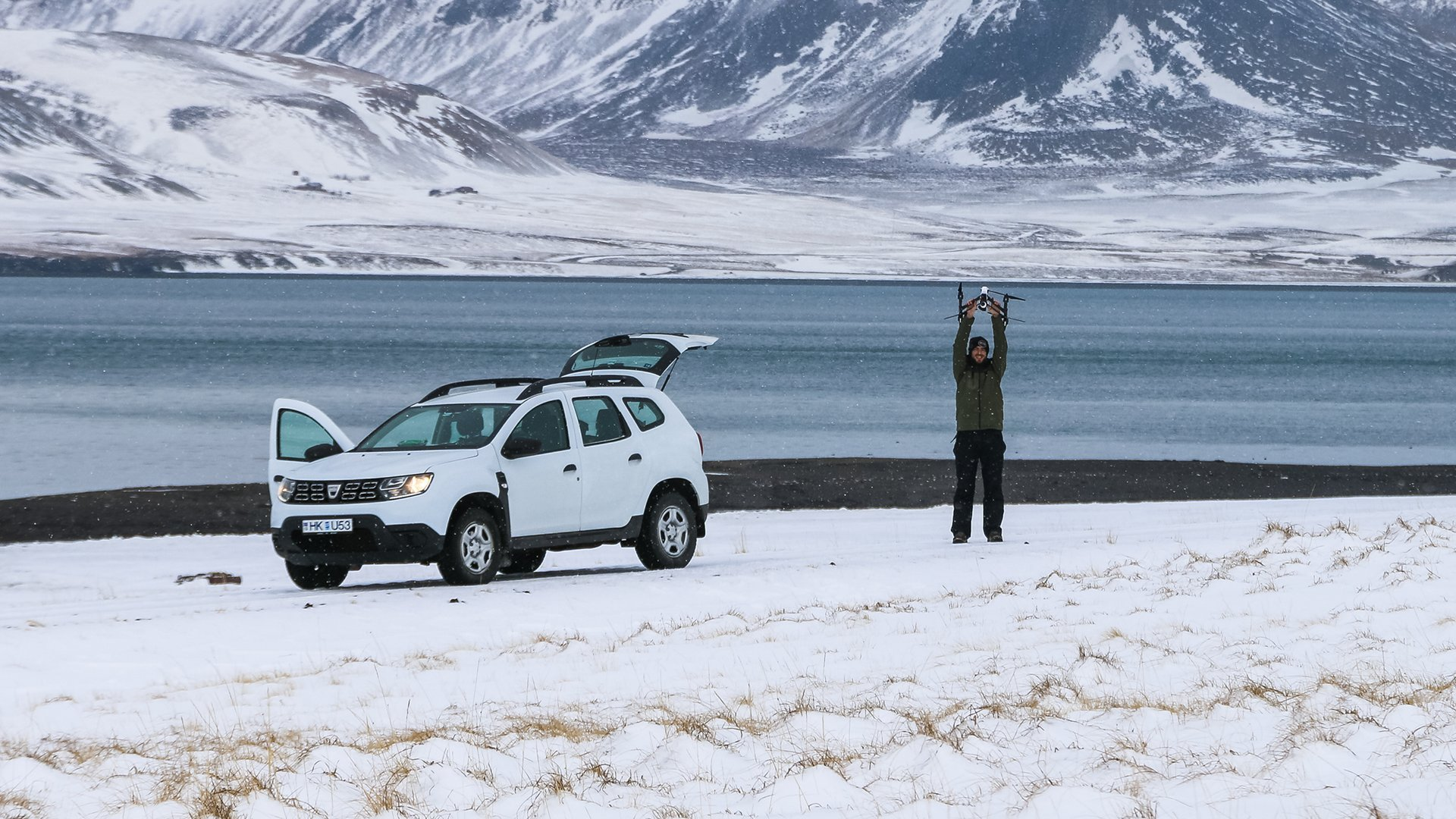 Dan Stood Holding Up Drone Next to Car in Icy Environment