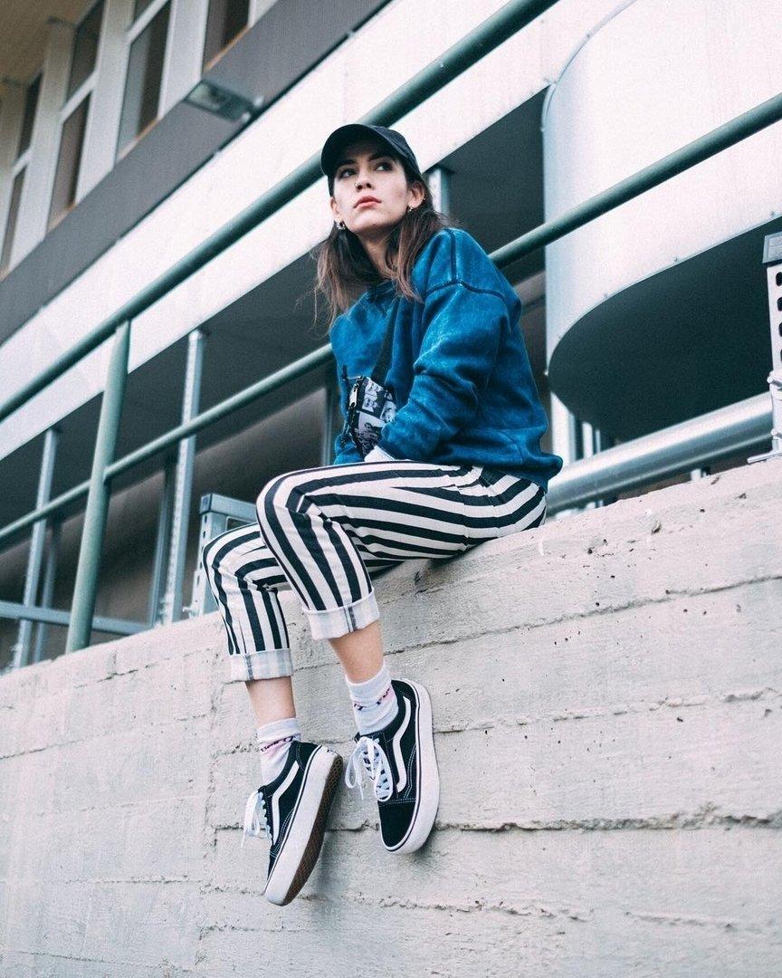 Tyylikäs nuori nainen Vans Old Skoolit jalassa