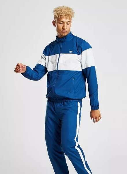 Ung mand med blåt tracksuit fra Lacoste med en hvid stribe hen over brystet