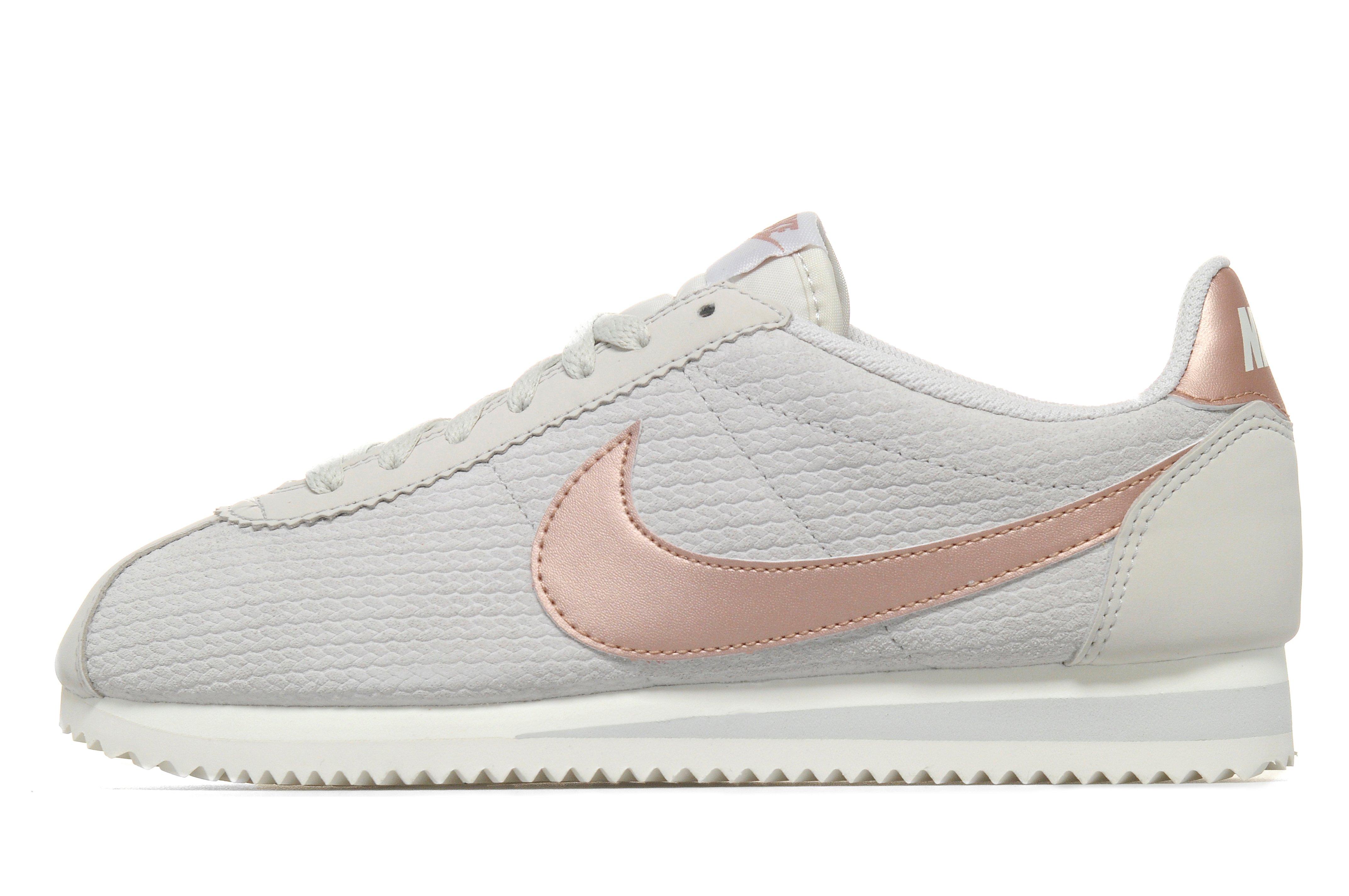 pink nike cortez with gold swoosh