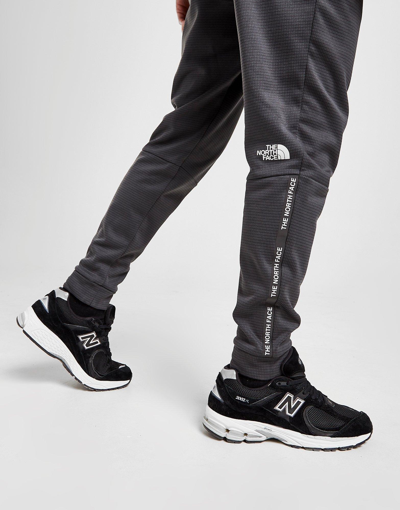 Pantaloni pentru bărbați THE NORTH FACE PANTALONI  TRAIN N LOGO TRACK PANTS NF0A5IJM0C51 Gri