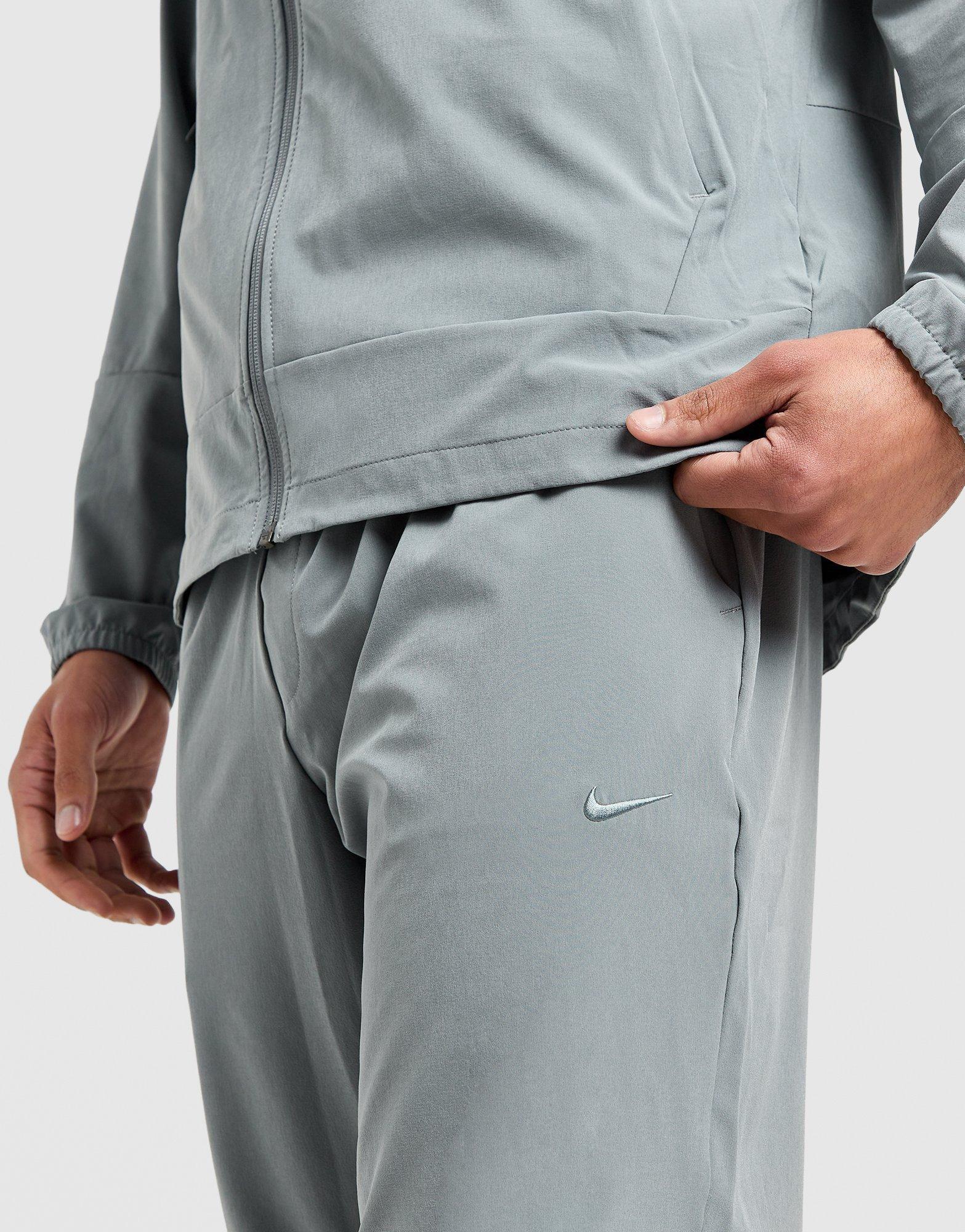 Мъжко фитнес облекло NIKE ПАНТАЛОНИ M NK DF UNLIMITED PANT TPR FB7548-084 Сив