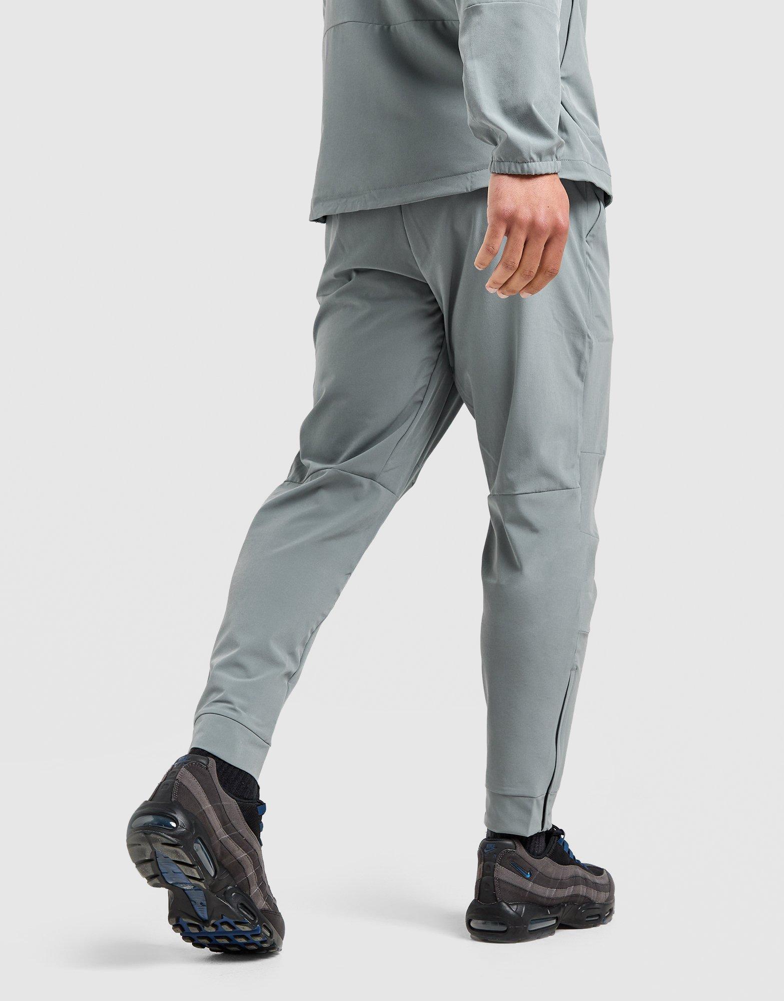 Мъжко фитнес облекло NIKE ПАНТАЛОНИ M NK DF UNLIMITED PANT TPR FB7548-084 Сив