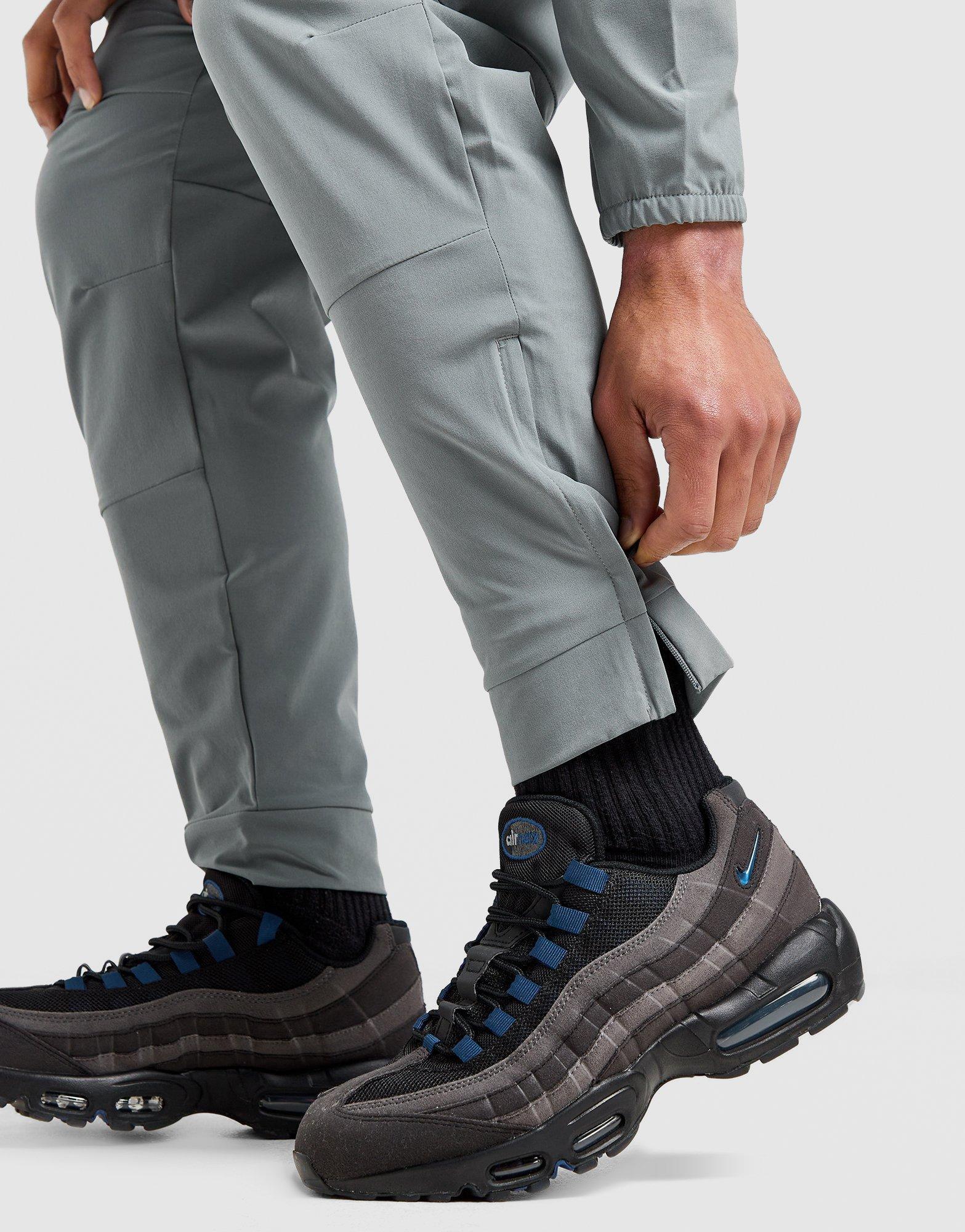 Мъжко фитнес облекло NIKE ПАНТАЛОНИ M NK DF UNLIMITED PANT TPR FB7548-084 Сив