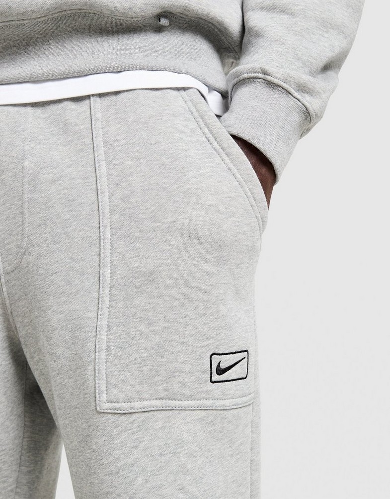 Pantaloni pentru bărbați NIKE PANTALONI  FLC WORKER JOGGER IQ2768-063 Gri