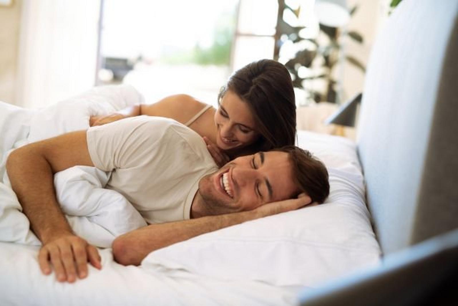 A couple laying in bed laughing